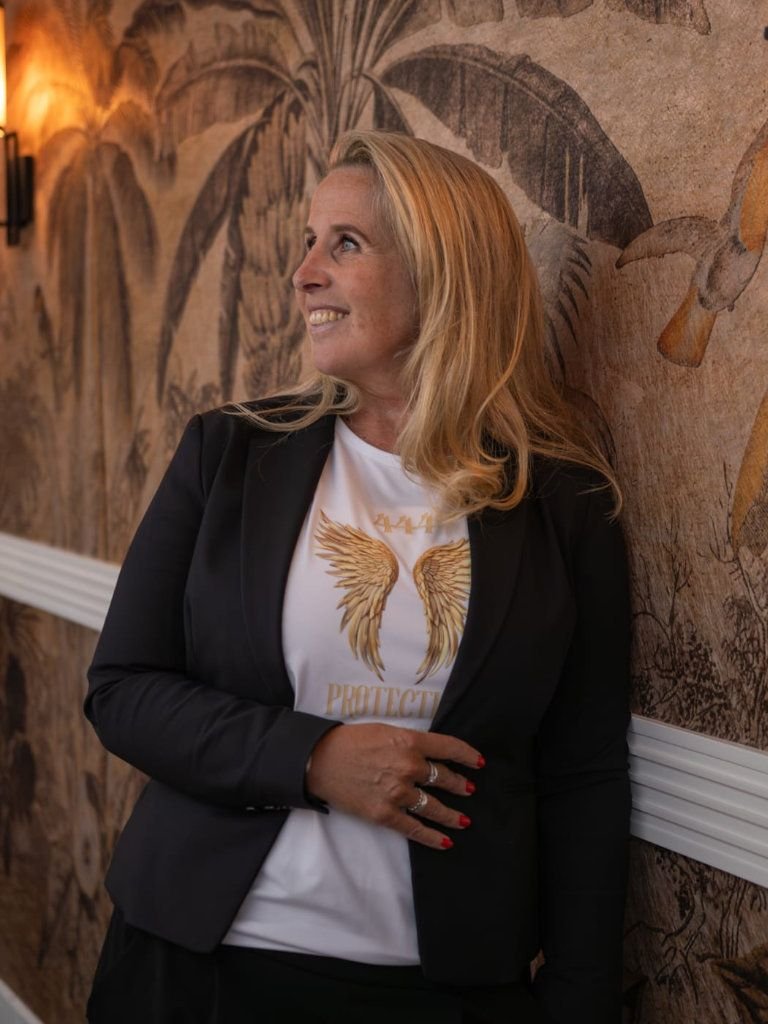 Persoonlijke profielfoto van de oprichtster van Next Level Assistant, werkend achter een laptop in een lichte kantooromgeving.