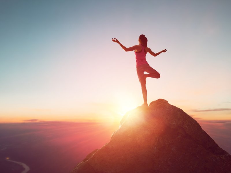 Ondernemer met uitgestrekte armen in de natuur, symbool voor loslaten en hernieuwde vrijheid.
